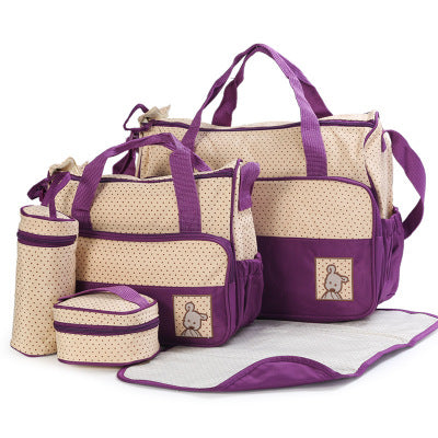 5-piece beige and purple polka dot diaper bag set with changing pad, bottle holder, and small bags.