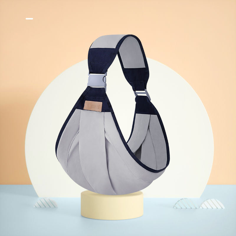 Ergonomic gray and navy baby sling carrier with adjustable strap and metal buckles.