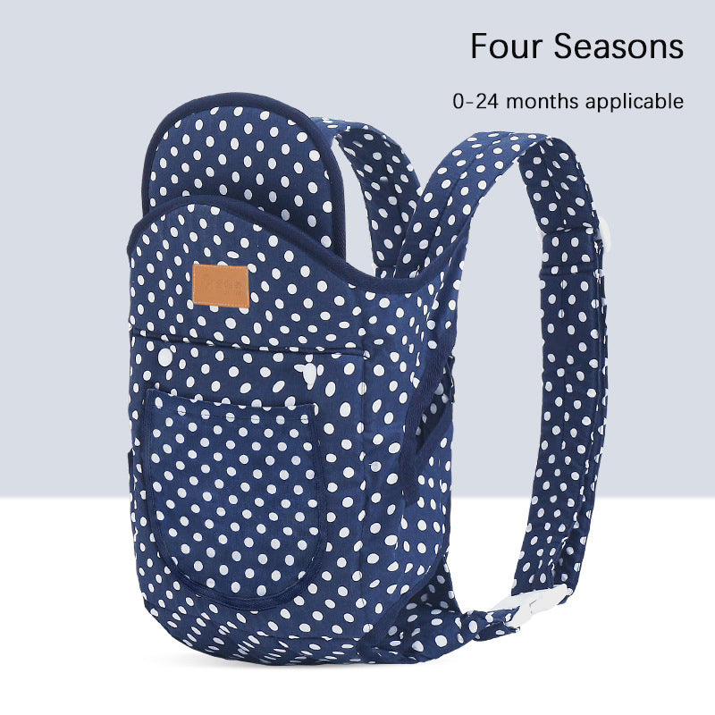 Navy blue ergonomic baby carrier with white polka dots, suitable for 0-24 months.