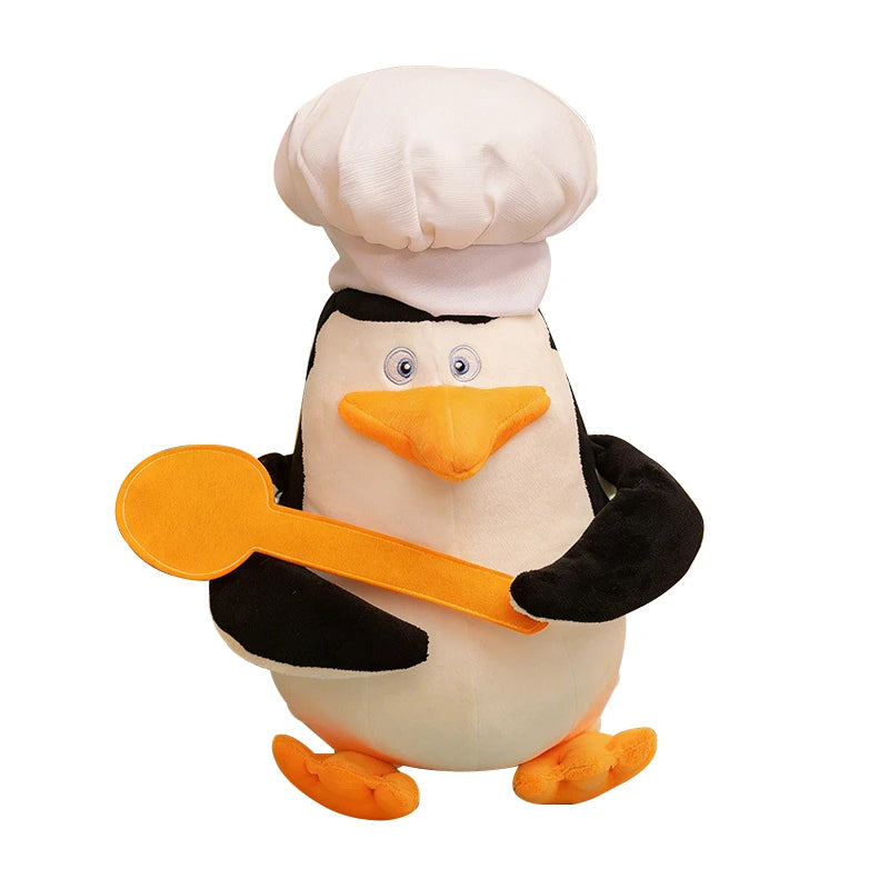 Soft 28cm Madagascar plush penguin toy in a chef's hat, holding an orange spoon.