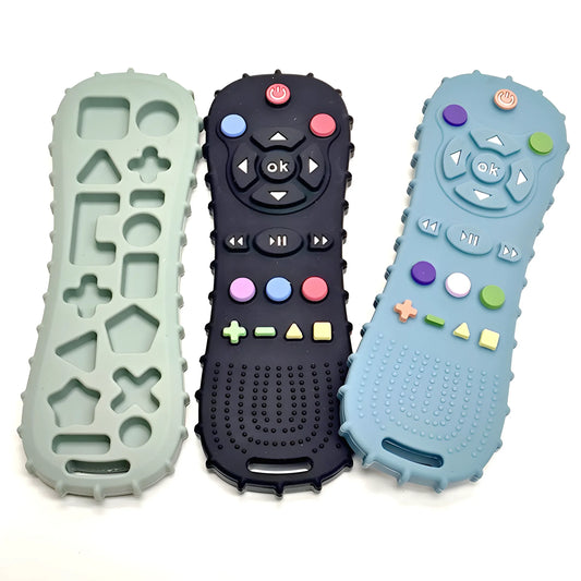 Three silicone remote control teethers in green, black, and blue with textured surfaces and colorful buttons.