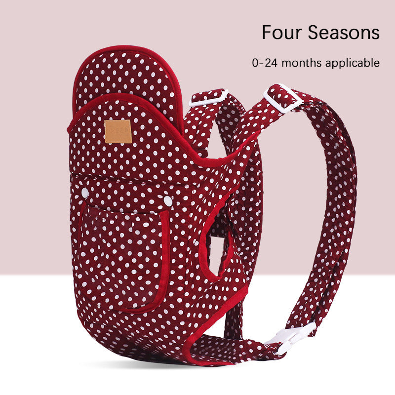 Red polka dot ergonomic baby carrier with white straps, suitable for front and back carry.