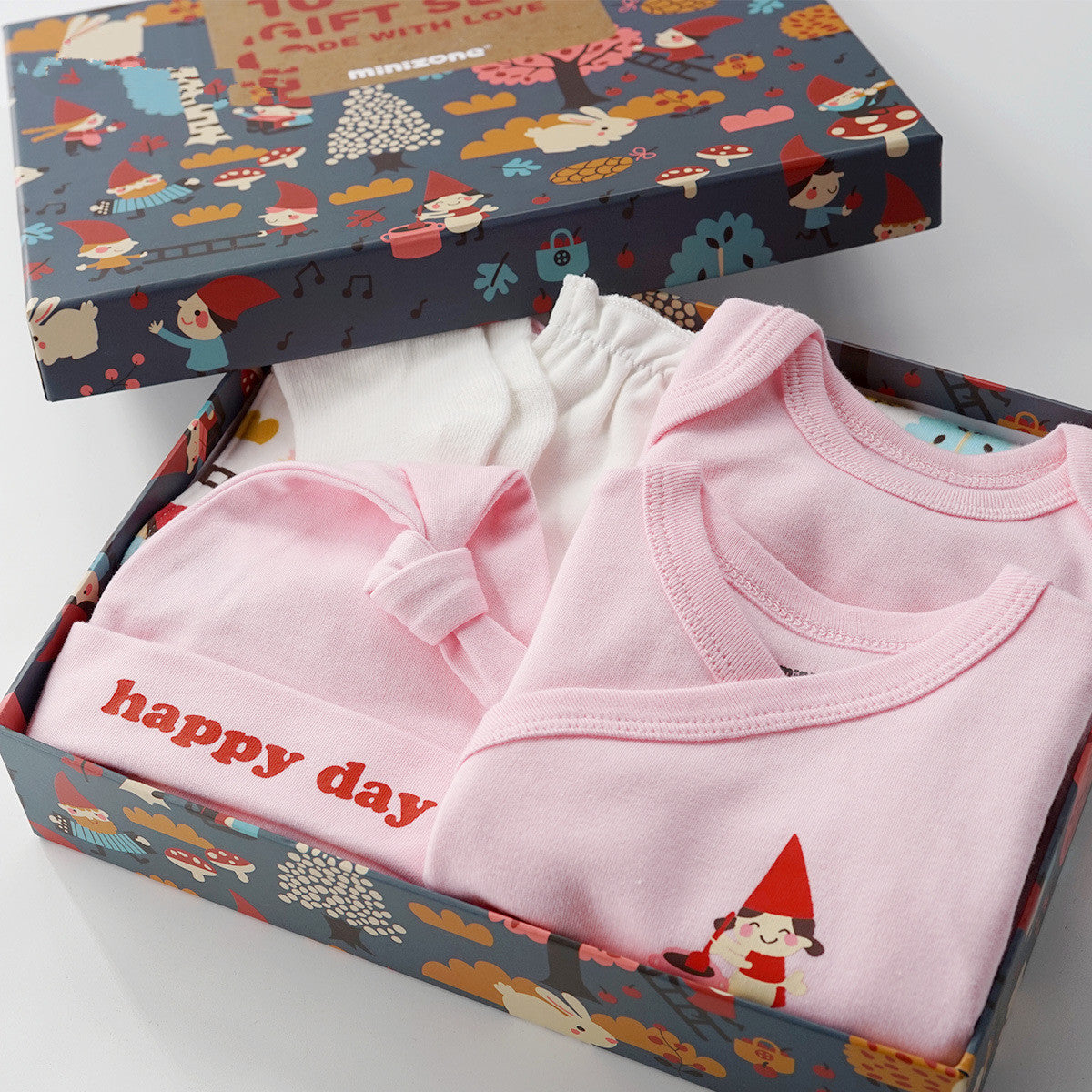 Pink and white 10-piece unisex baby gift set in a gnome-patterned box, made of soft cotton.