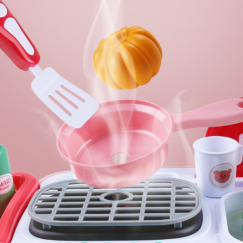 Pink plastic toy kitchen set with steaming pumpkin, spatula, and pan.