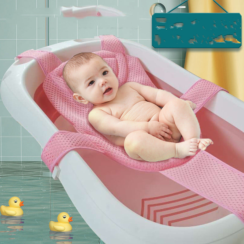 Baby in pink mesh bath support sling in a white tub with two yellow rubber ducks.