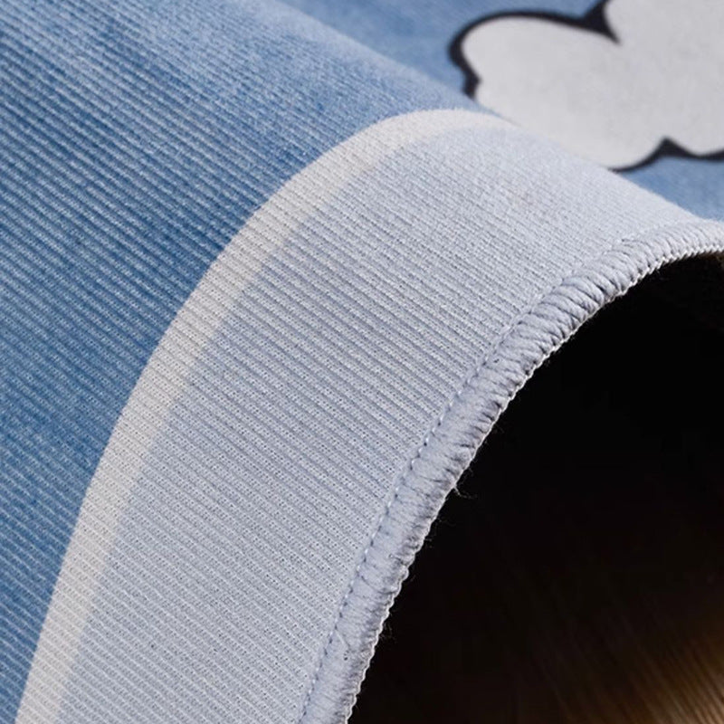 Soft blue crystal velvet kids' rug with white cloud cartoon design, showing plush texture and stitched edge.