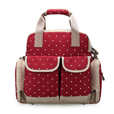 Red polka dot diaper backpack with beige trim, multiple pockets, and top handles.