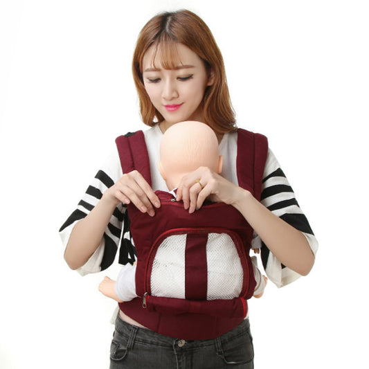 Woman demonstrating a maroon ergonomic baby carrier with breathable mesh pocket, holding a doll.