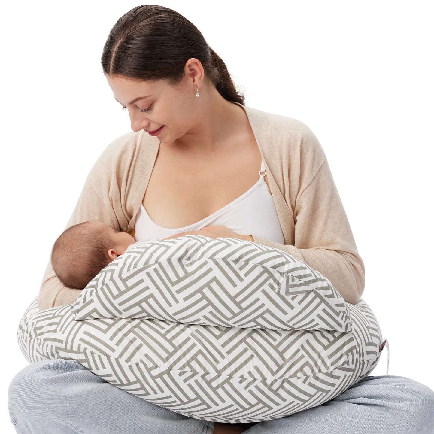 Mother breastfeeding baby using a gray and white geometric pattern nursing pillow.