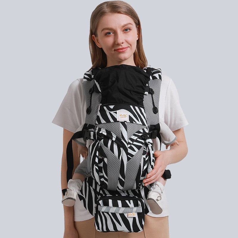 Woman wearing a black and white zebra print ergonomic cotton baby carrier with mesh accents.