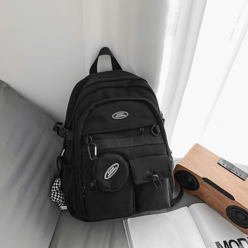 Black nylon student backpack with laptop compartment, multiple pockets, and a detachable round pouch.