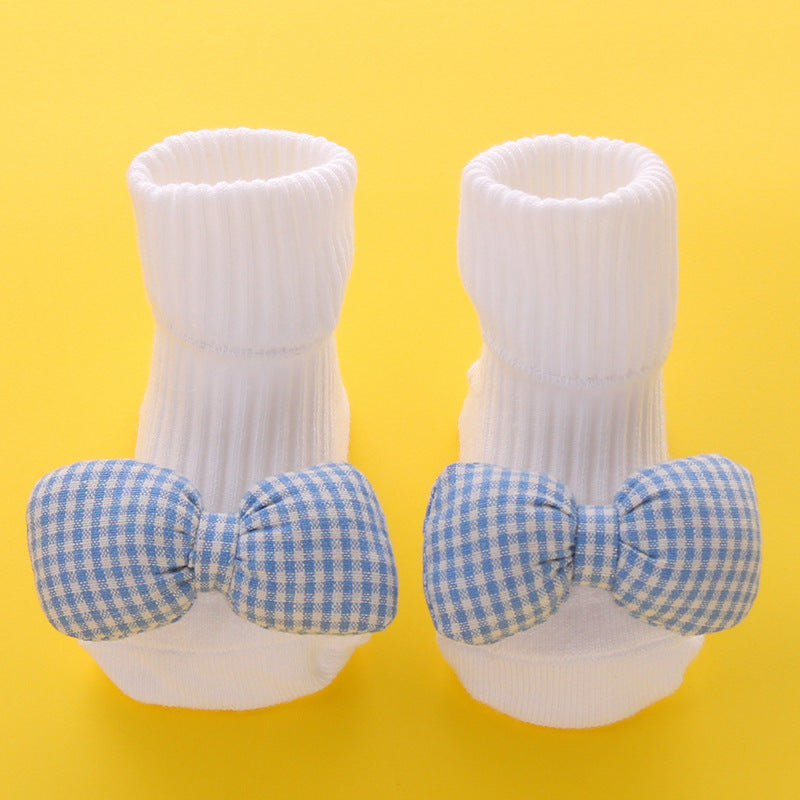 White cotton baby socks with blue gingham bow, anti-slip soles, for ages 0-3 years.