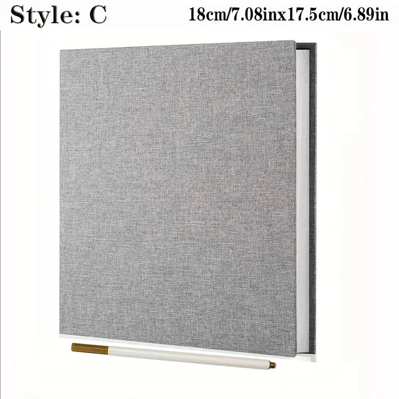 Gray linen hardcover photo album with spiral binding, 18cm x 17.5cm, and a gold marker pen.