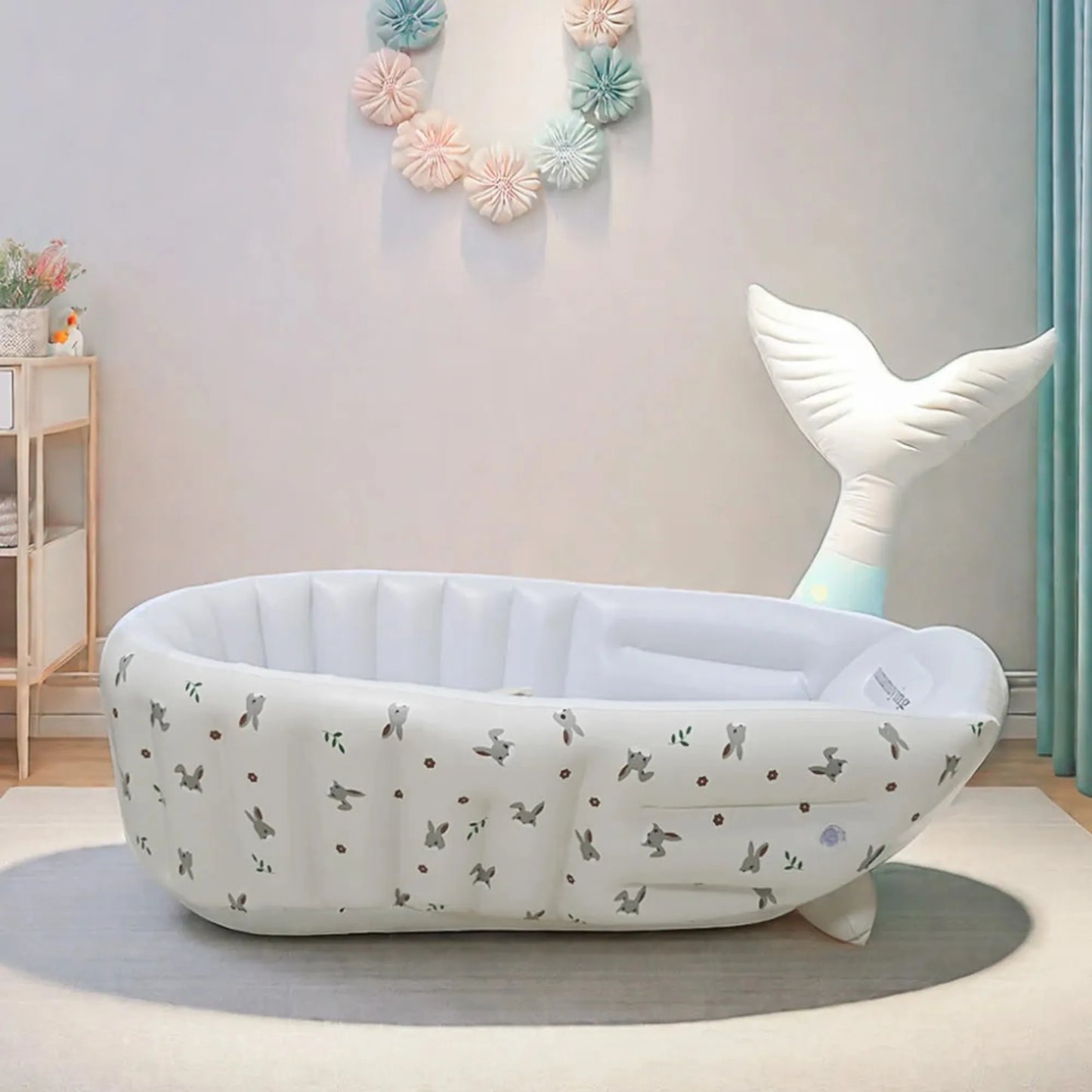 White inflatable baby bathtub with whale tail design and animal print, built-in pump.