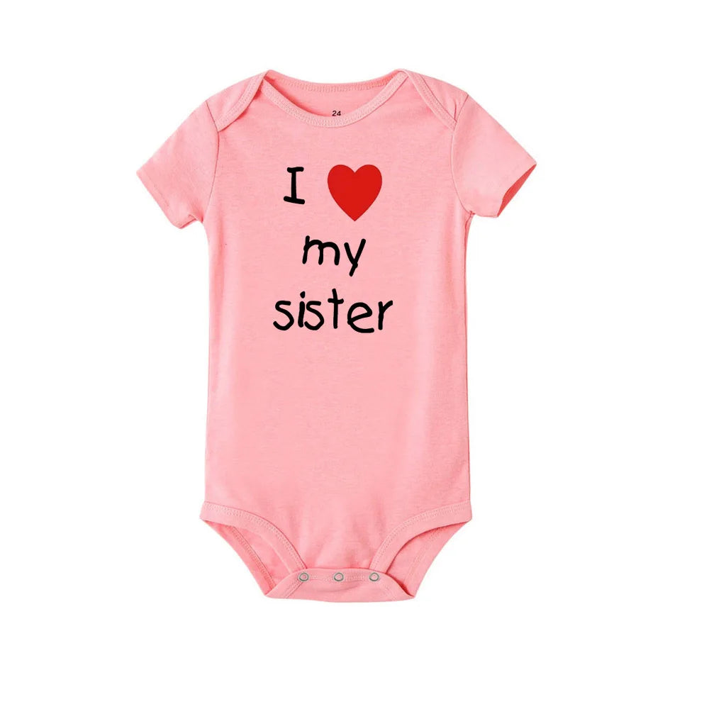 Pink short-sleeve baby romper with "I love my sister" print, round neck, and snap closure.