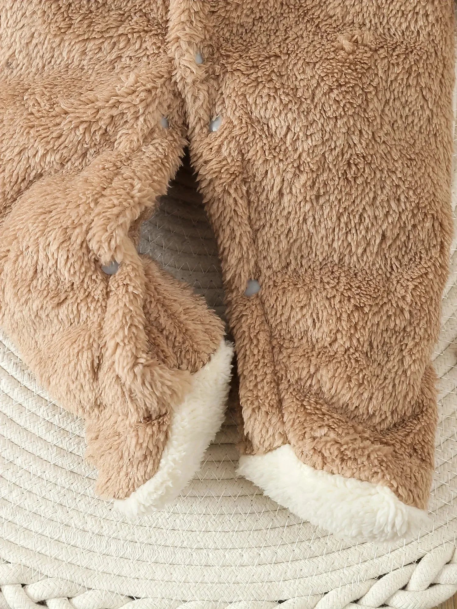 Brown plush fleece baby romper with snap closures and white sherpa lining.