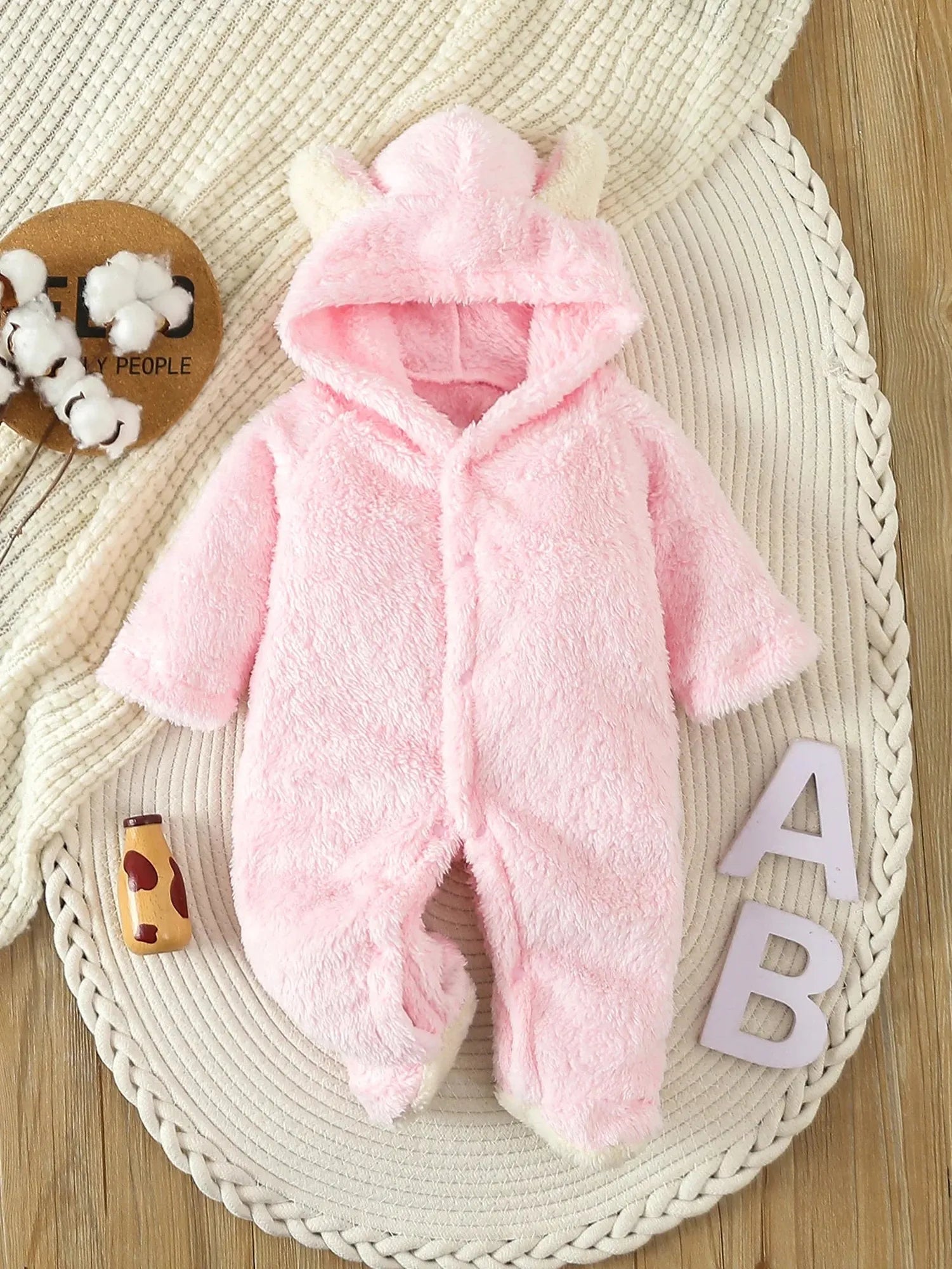 Soft pink fleece baby romper with a hooded design and cute ear details.
