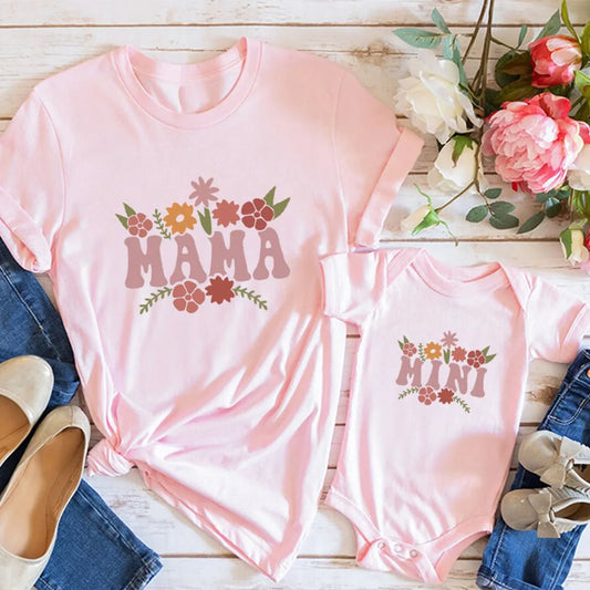 Pink "Mama" t-shirt and matching "Mini" baby bodysuit with floral designs, perfect for mother and baby.