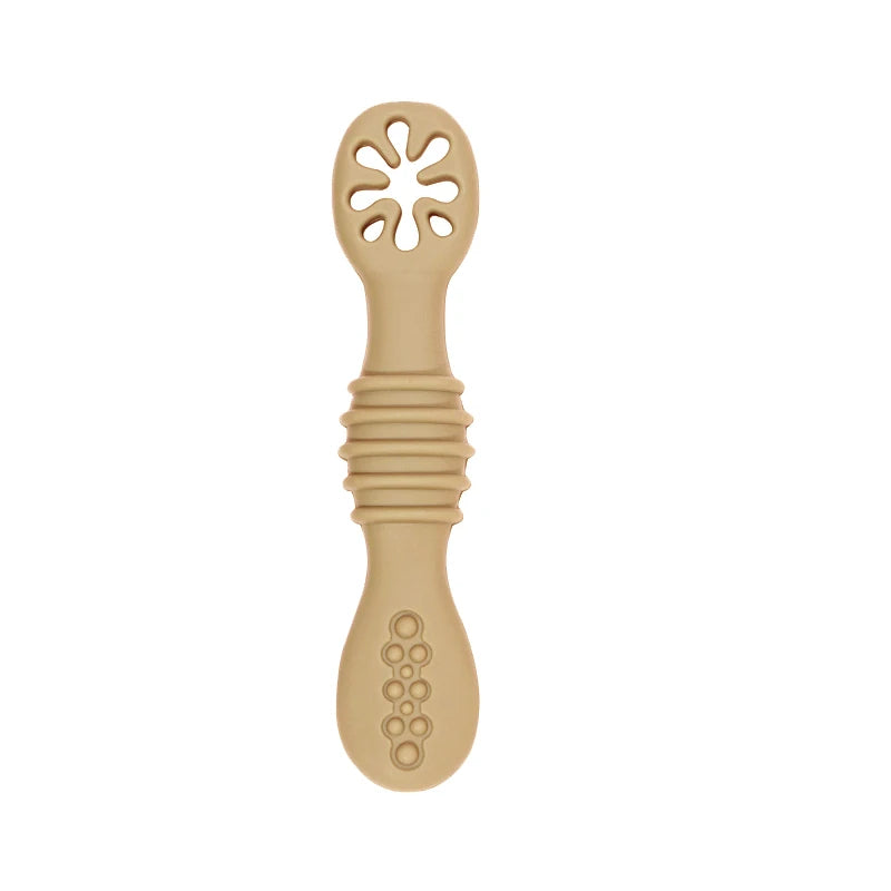 Beige silicone baby training spoon with soft, flexible tip and textured handle.