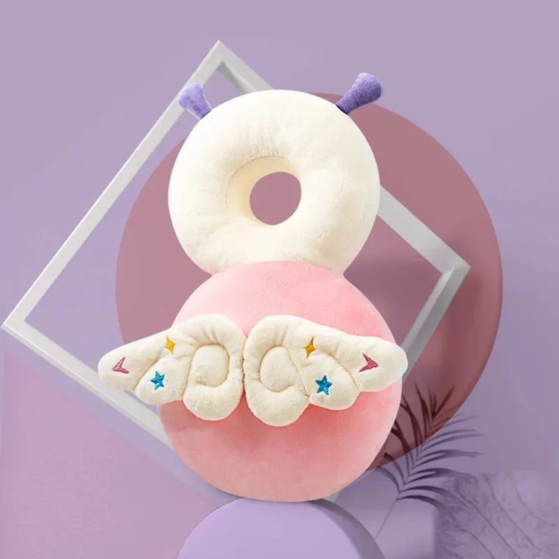 Pink baby head protection pillow with white top, purple antennae, and star-embroidered wings.