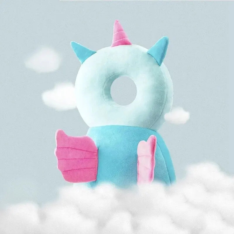 Light blue unicorn baby head protector with pink horn and wings, sitting on clouds.