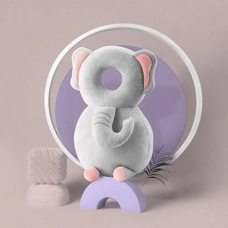 Gray elephant baby head protection pillow with pink ears and feet, on a purple arch.