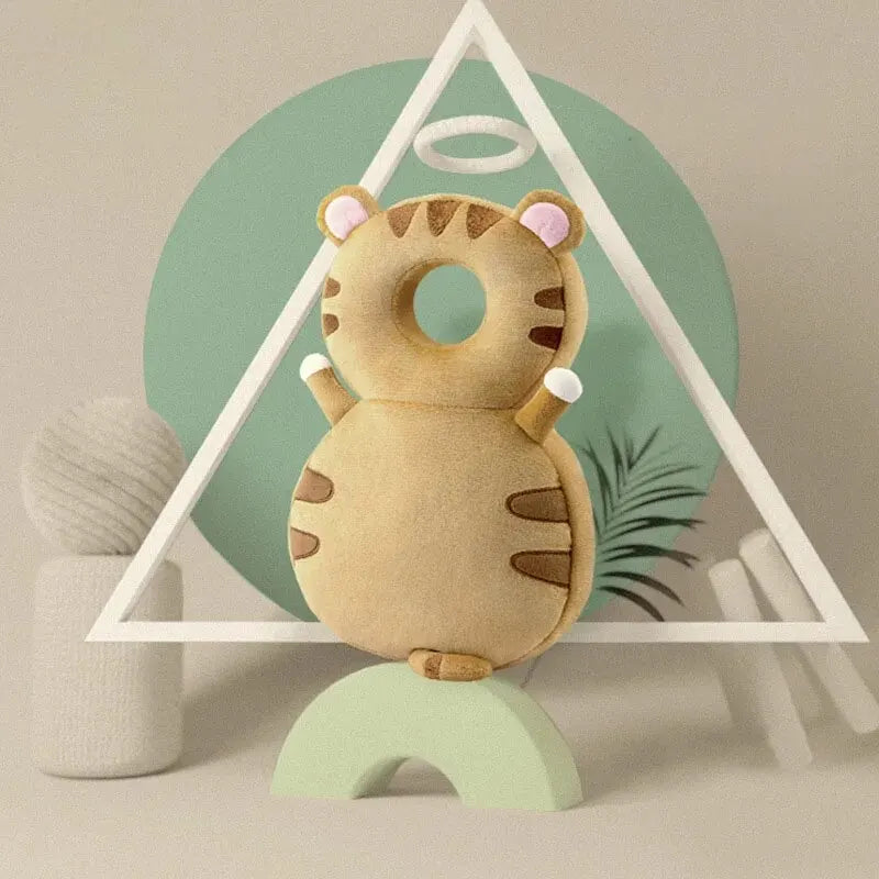Soft brown tiger baby head protection pillow with pink ears and white halo, on a green arch.