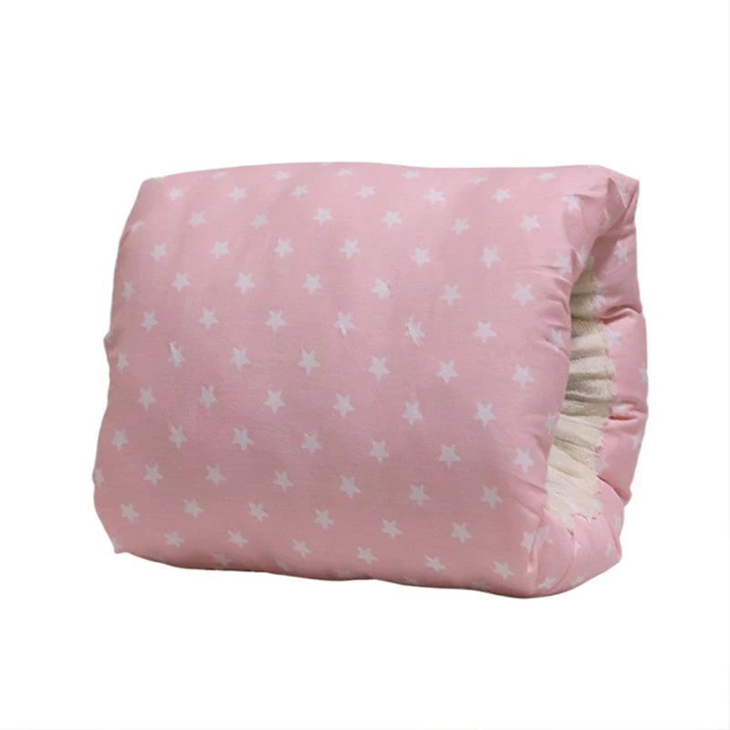 Pink cotton nursing pillow with white stars, designed for arm and neck support.