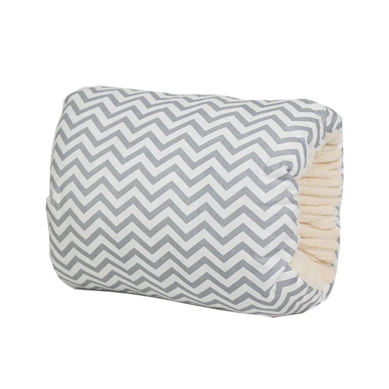 Gray and white chevron nursing pillow for arm support, with soft cream plush interior.