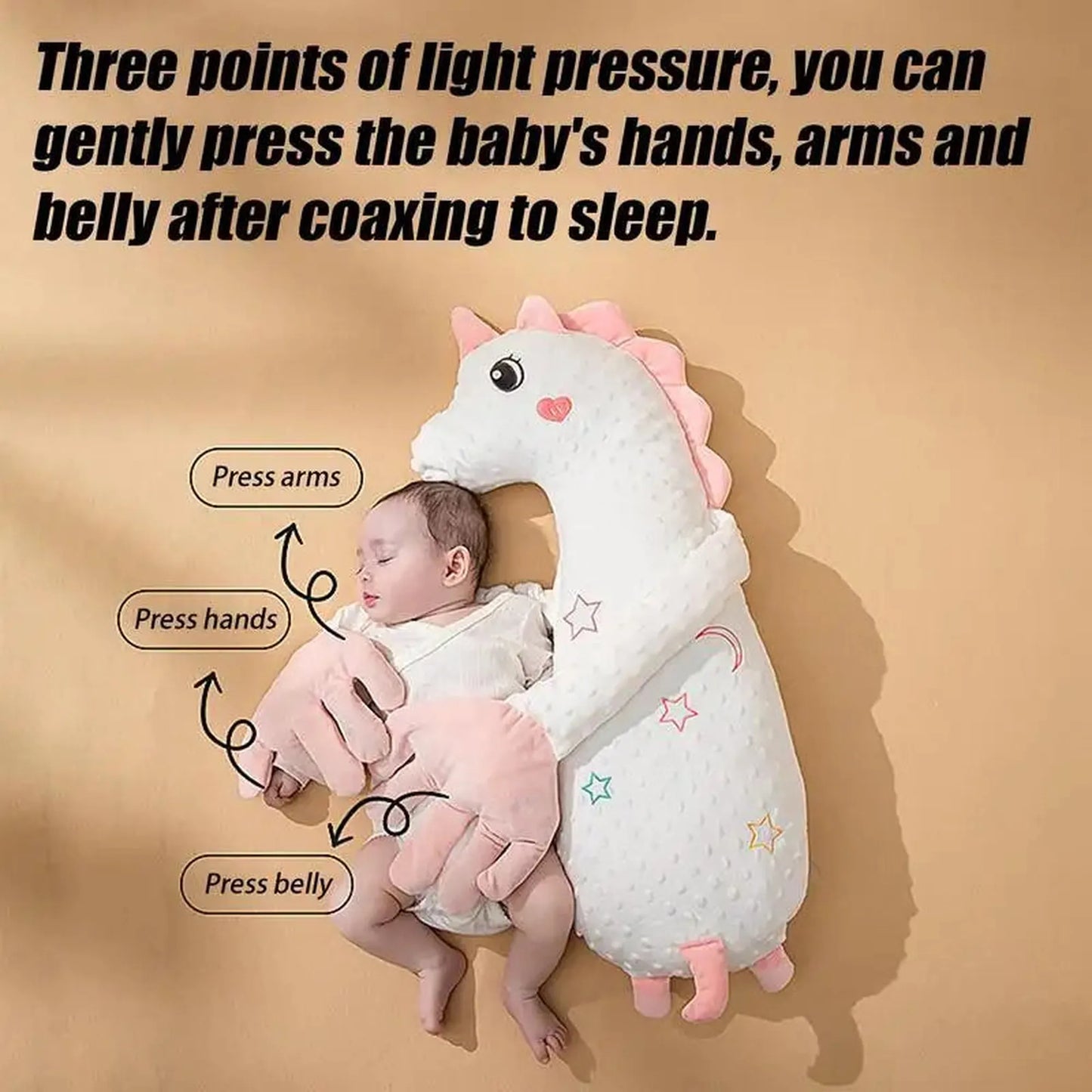 White unicorn baby soothing pillow with pink accents, gently hugging a sleeping infant.