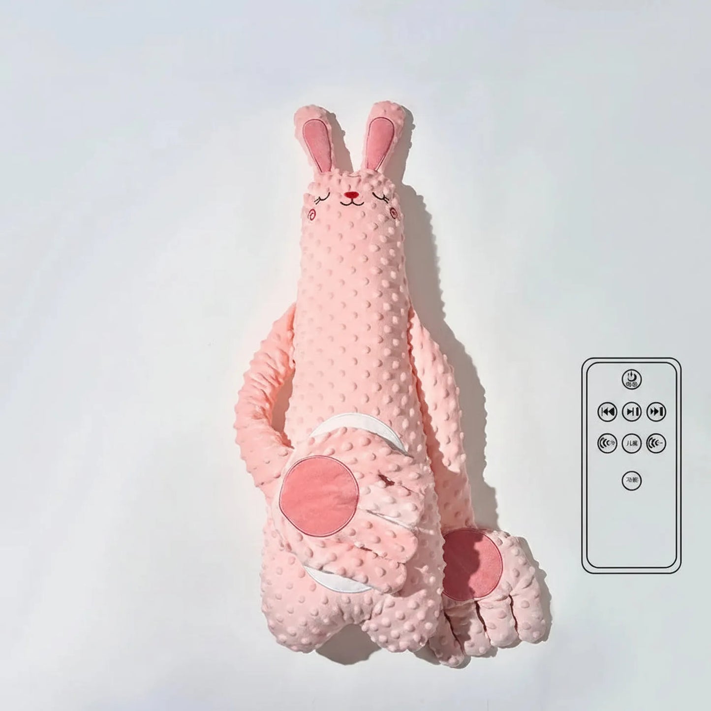 Pink plush bunny soothing pillow with a remote control, featuring a textured body and gentle hand design.