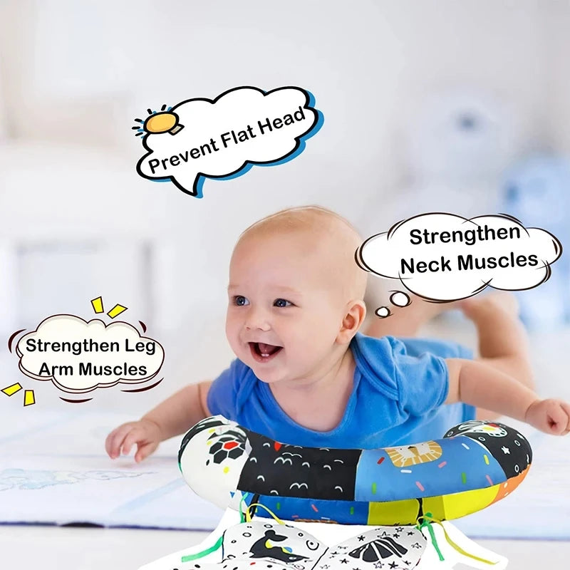 Happy baby on tummy time with a high-contrast black and white developmental pillow.
