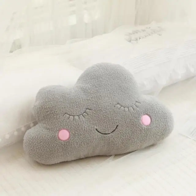 Soft gray cloud-shaped plush pillow with embroidered sleeping eyes and pink rosy cheeks for nursery decor.