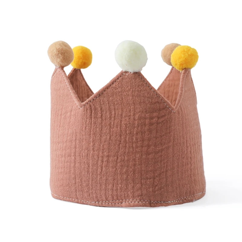Pink cotton baby birthday crown with colorful pom-poms for festive celebrations.