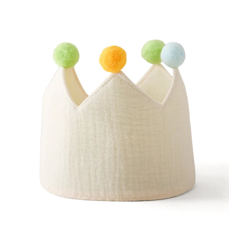 Cream cotton baby birthday crown with colorful pom-poms for festive celebrations.
