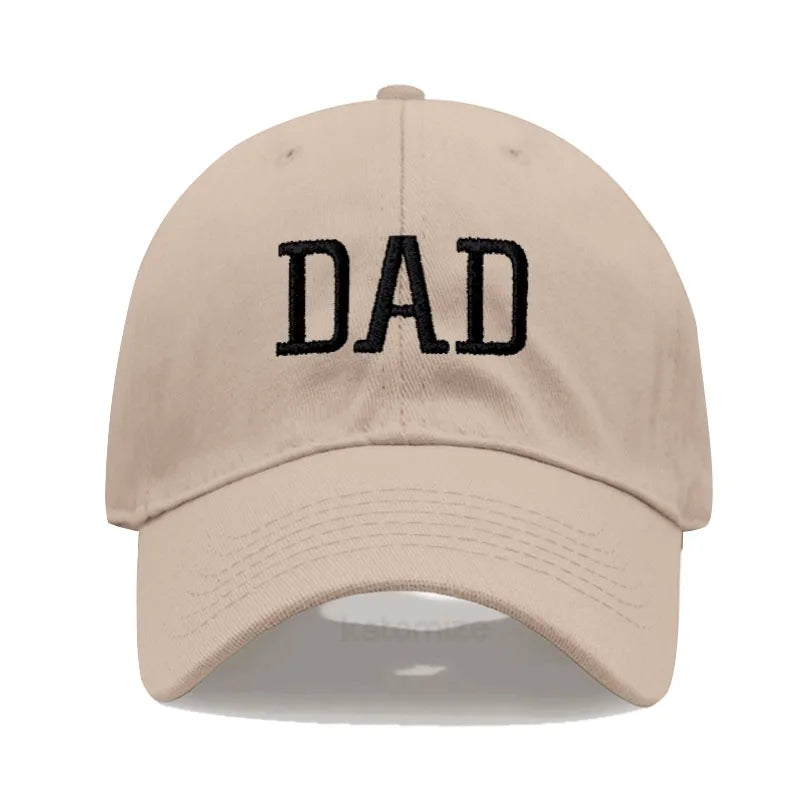 Adjustable beige cotton baseball cap with "DAD" embroidered in black.