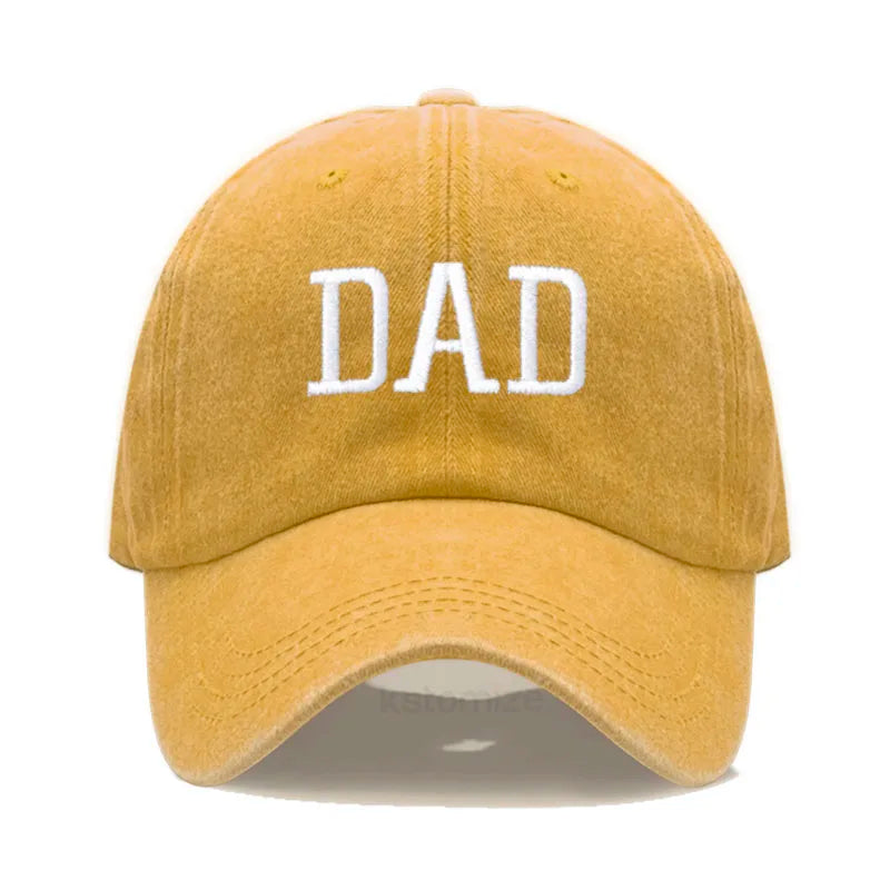 Adjustable mustard yellow cotton baseball cap with "DAD" embroidered in white.