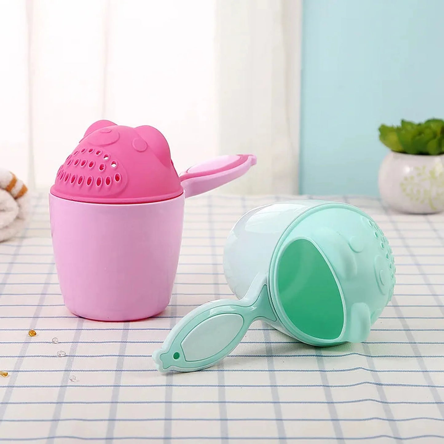 Pink and mint green bear-shaped baby bath rinse cups with comfortable handles.