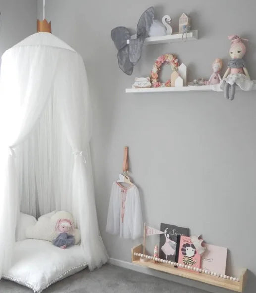 White sheer canopy with gold crown accent over a baby bed, decorated with stars.