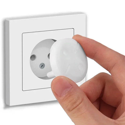 White ABS child safety plug for French/European electrical outlets, shown with a hand inserting it.