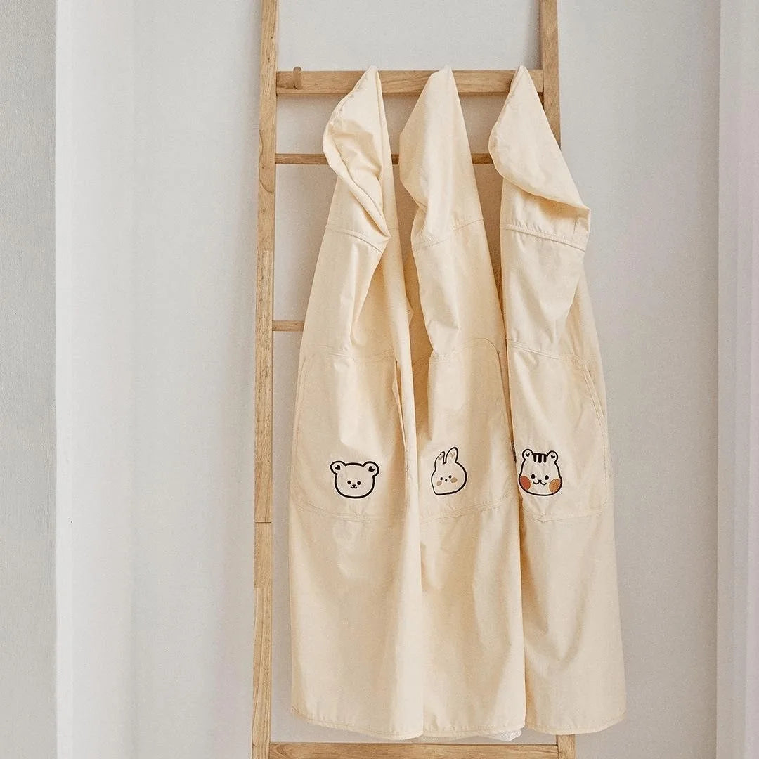 Three beige polyester baby carrier/stroller covers with hoods, featuring bear, bunny, and tiger designs.