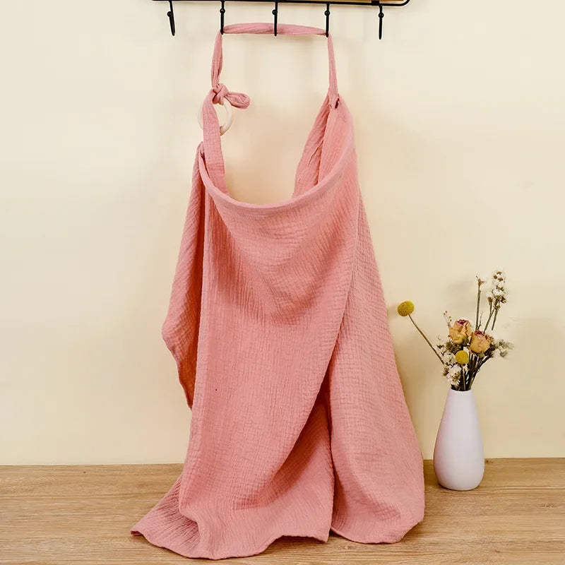 Pink cotton nursing cover and stroller blanket with adjustable strap and wooden ring.