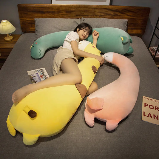Woman sleeping with a large yellow giraffe plush pillow, a green dinosaur, and a pink flamingo plush.