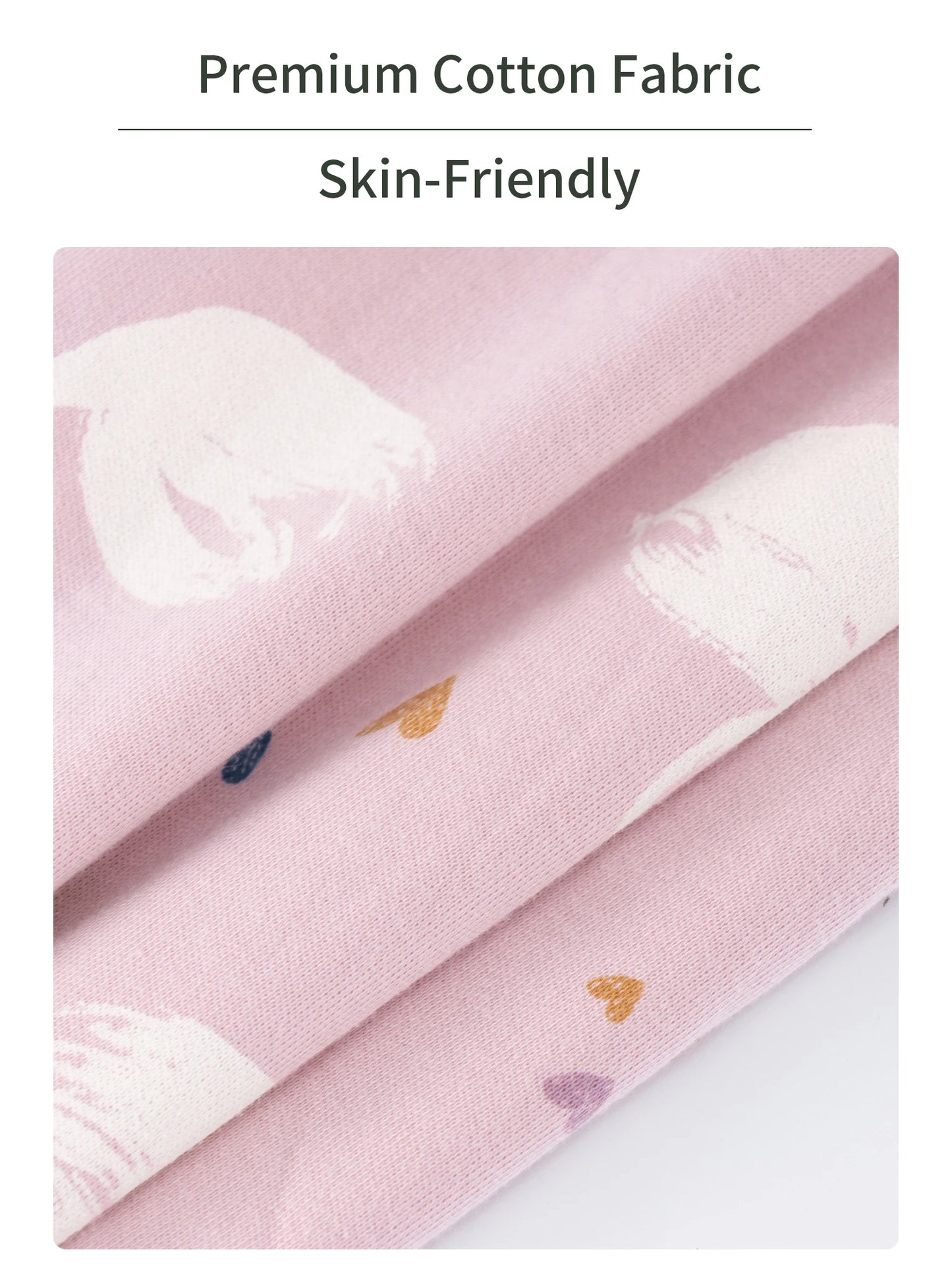 Close-up of soft pink cotton fabric with white, yellow, and purple heart patterns, highlighting its skin-friendly texture.