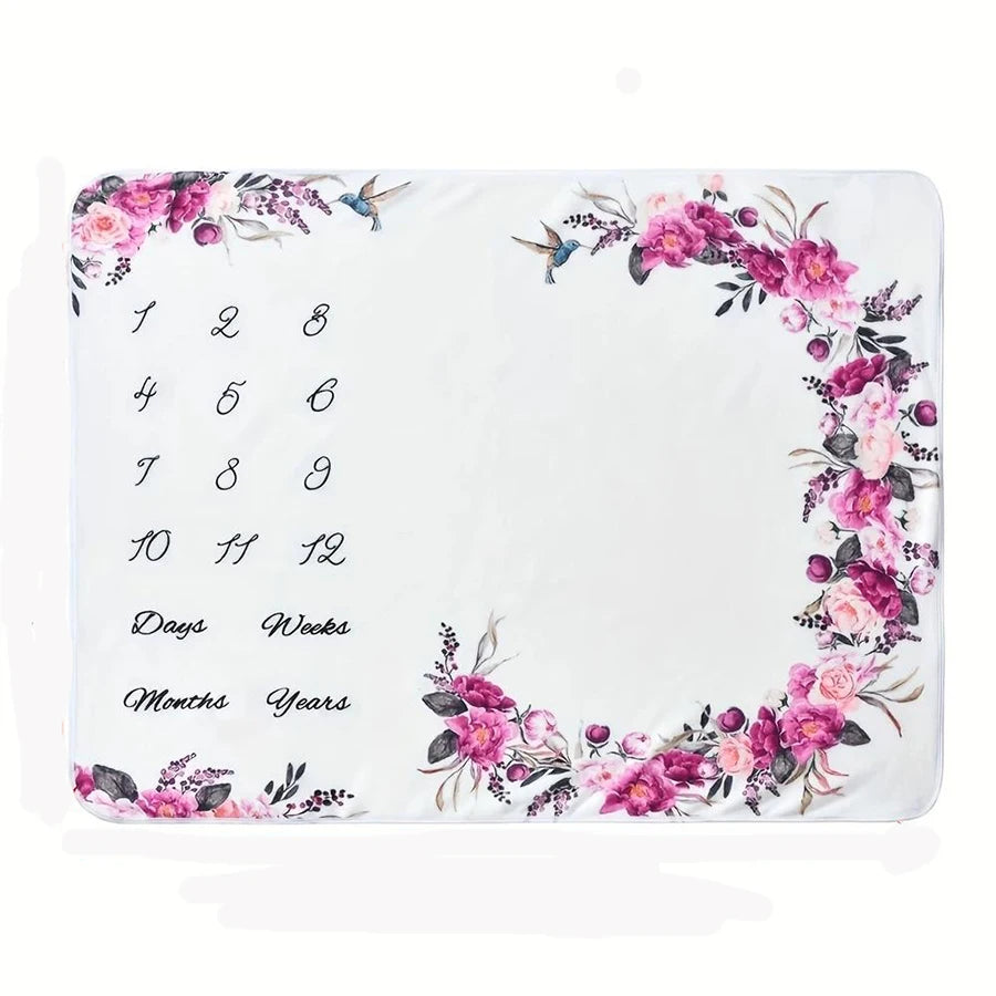White polyester baby milestone blanket with pink and purple floral wreath, numbers 1-12, and time markers.