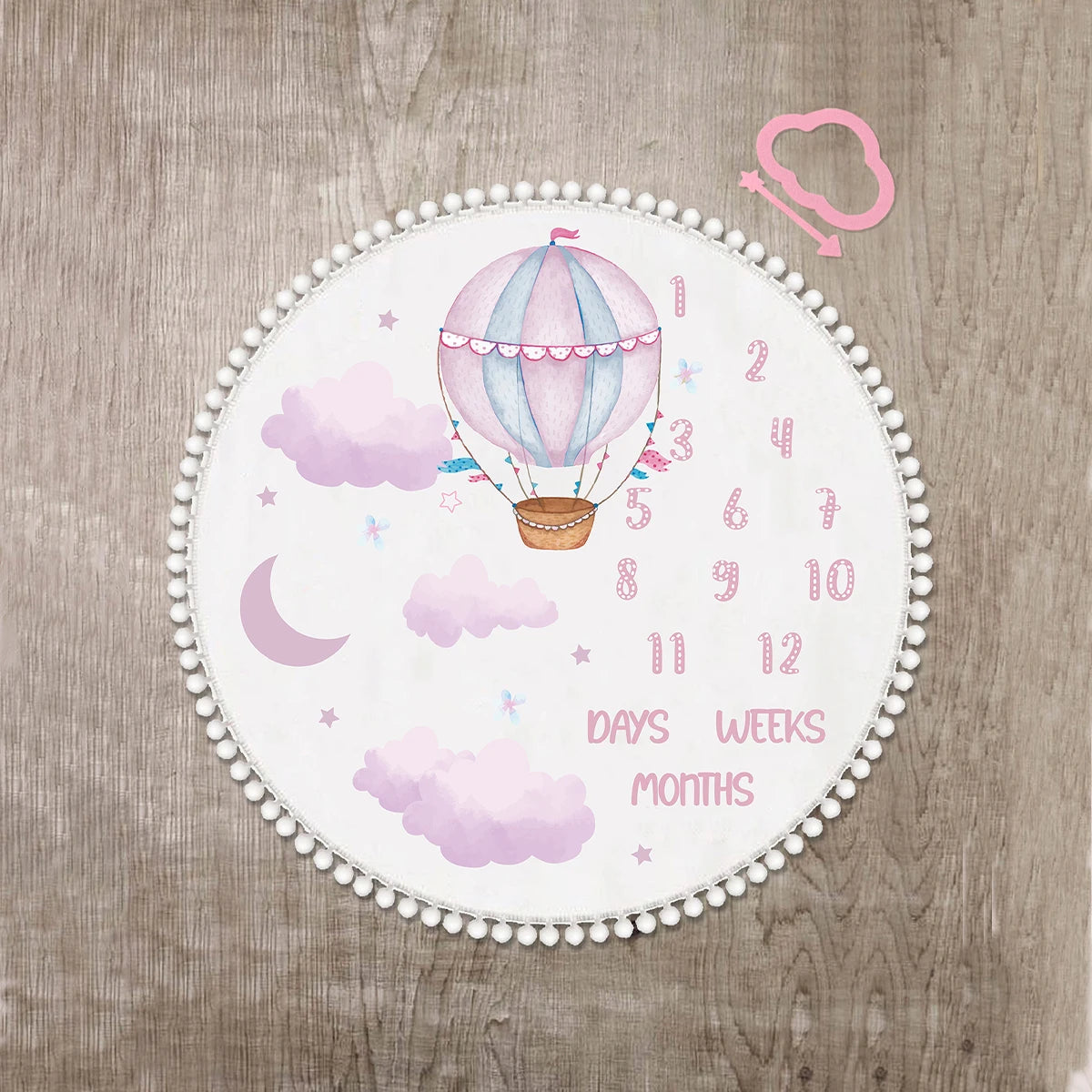 White flannel baby milestone blanket with pink hot air balloon, clouds, moon, and numbers 1-12.