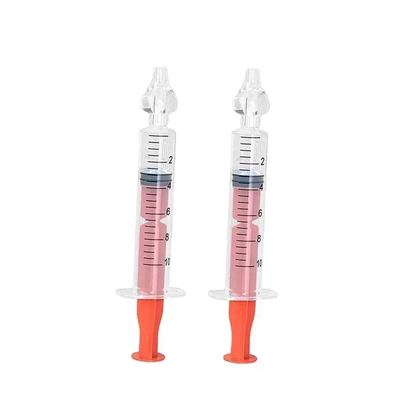 Two 10ml clear baby nasal aspirators with soft silicone tips and orange plungers, filled with pink liquid.