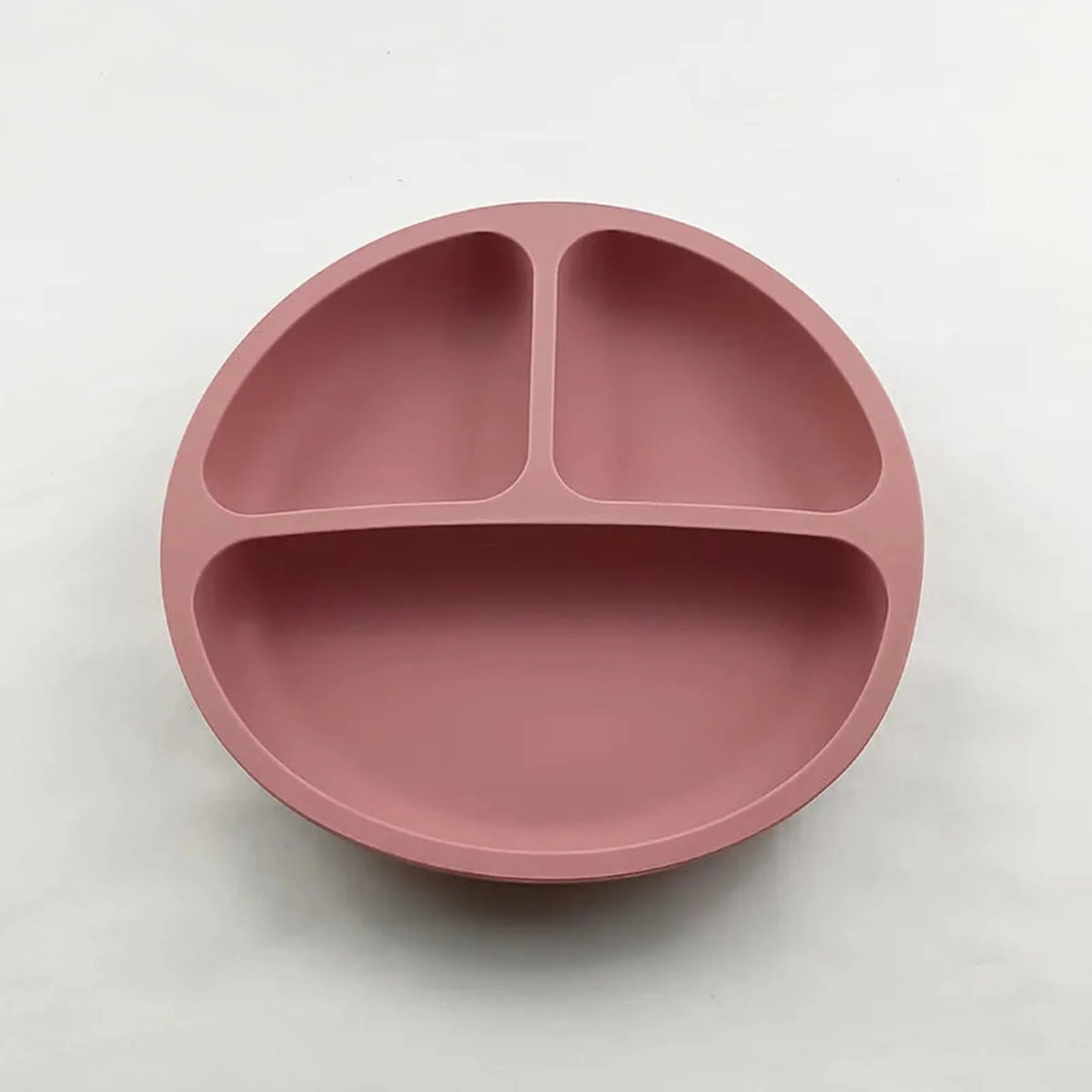 Pink silicone suction plate for self-feeding, with three divided sections for toddlers.