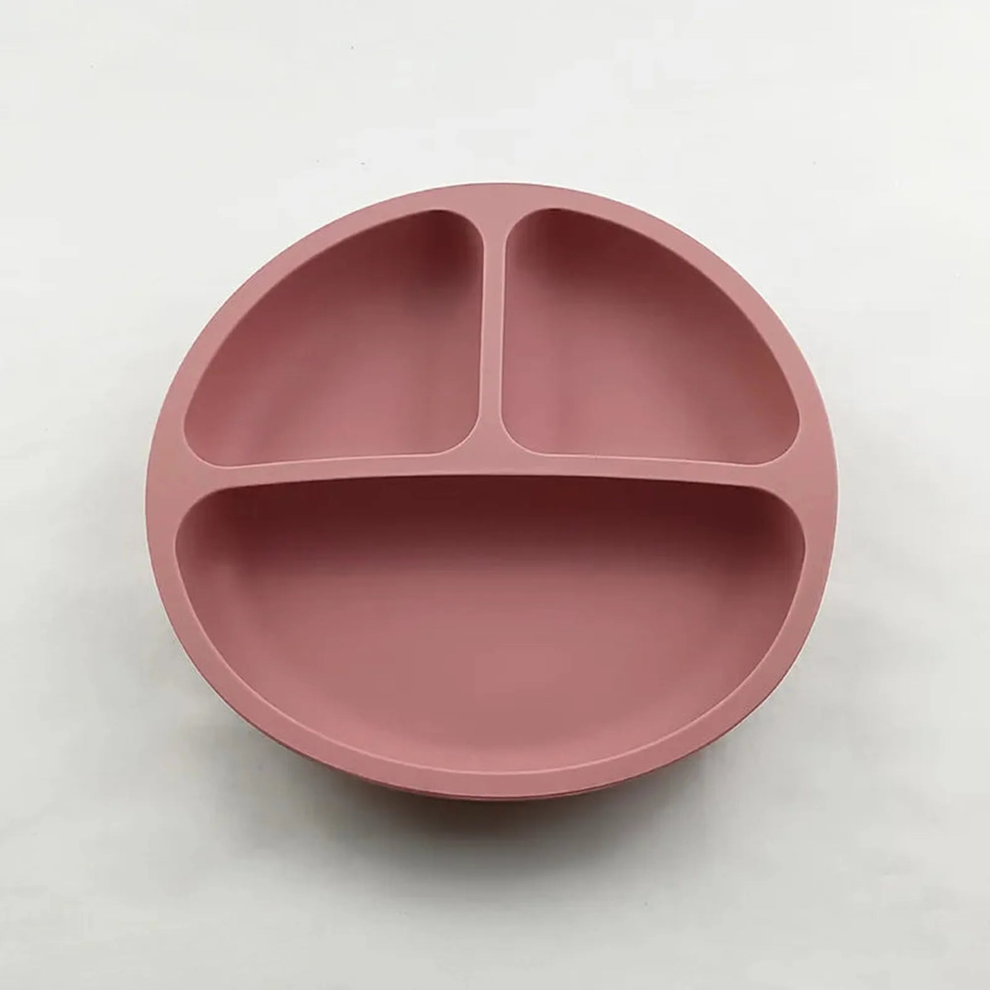Pink silicone suction plate for self-feeding, with three divided sections for toddlers.