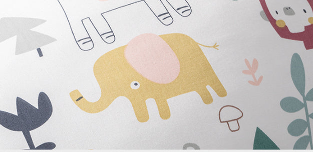 Close-up of a white nursing pillow with a playful yellow elephant and jungle animal pattern.